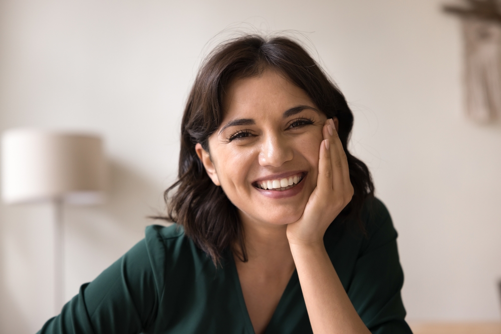 Woman relaxing outdoors with a bright smile, highlighting cosmetic dentistry and teeth whitening in La Jolla San Diego