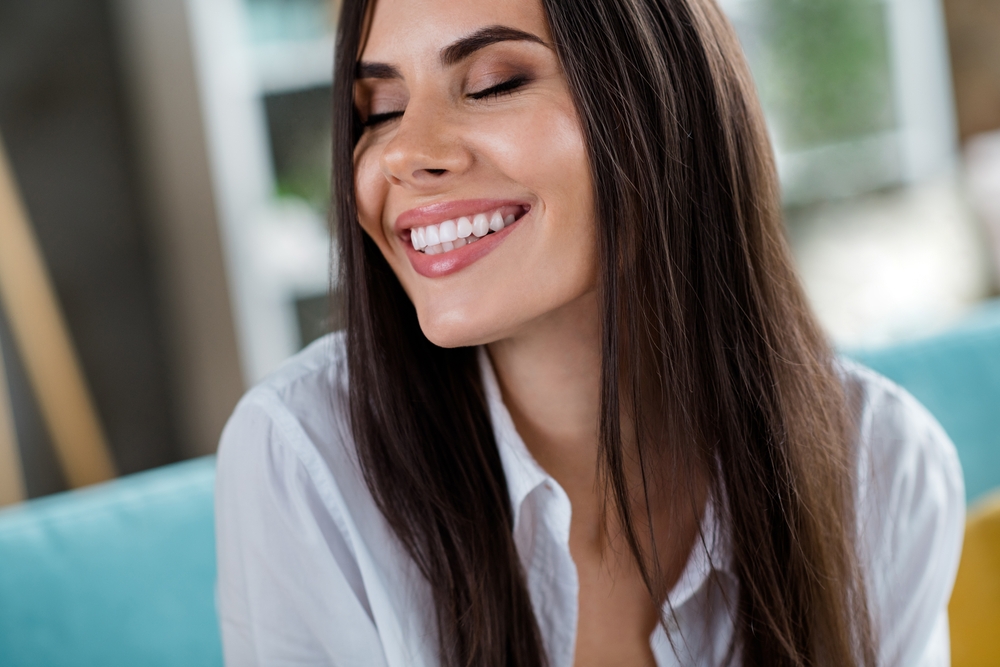Natural White Smile: Veneers Results in the San Diego Community Woman smiling indoors with a natural, white smile, the kind of result veneers can help patients in the San Diego community achieve