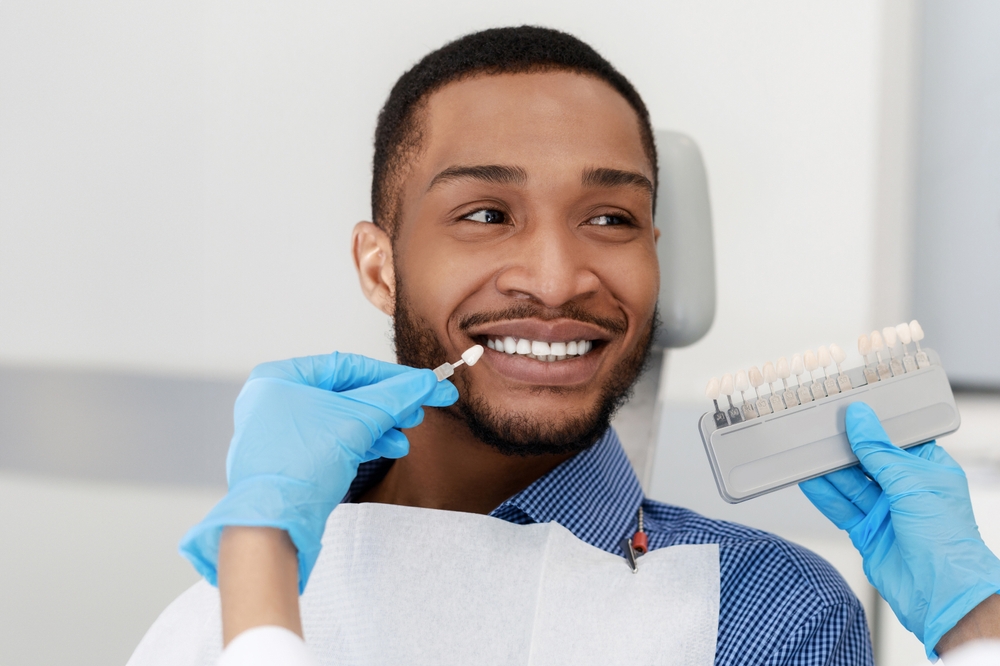 Tooth Shade Matching: Male Patient During a San Diego Community Dental Visit Dental patient having his tooth shade matched with a shade guide during a visit to a San Diego community dental office