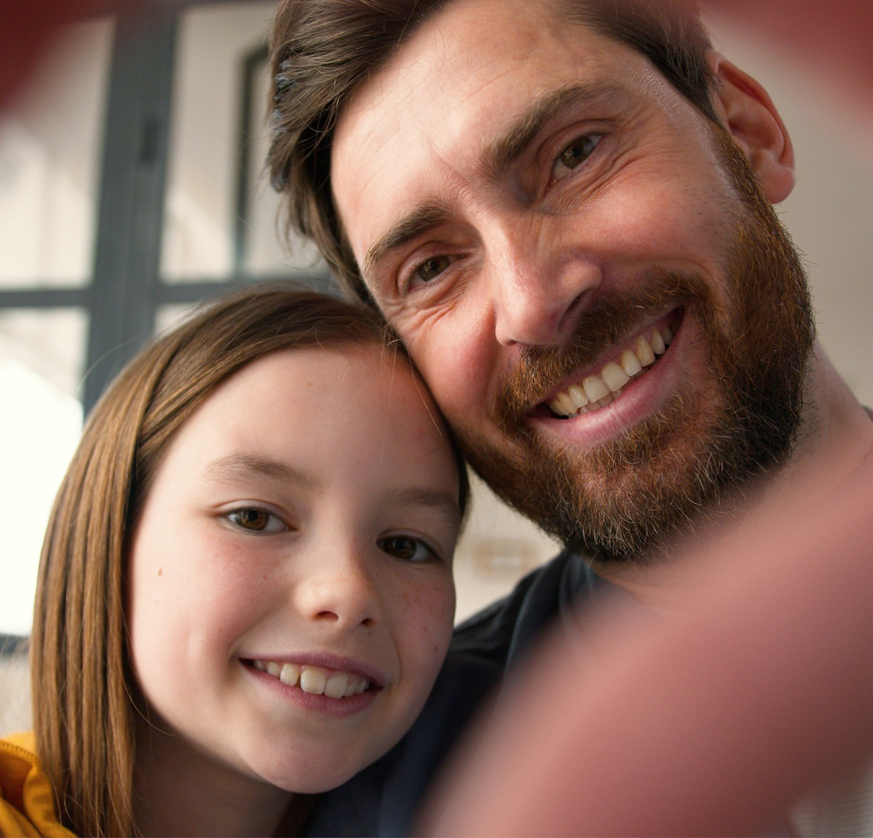 Father and daughter smiling for a selfie, representing comfortable family dental care in San Diego