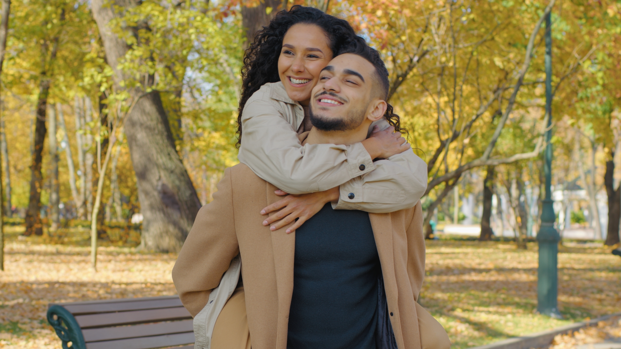 Young couple embracing outdoors in a park, reflecting the healthy, confident smiles supported by dental care in the San Diego community 
