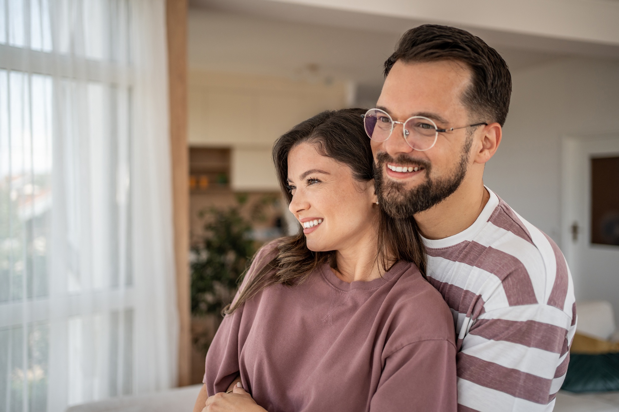 Happy couple smiling together at home, reflecting confident results from cosmetic and general dental care in La Jolla San Diego