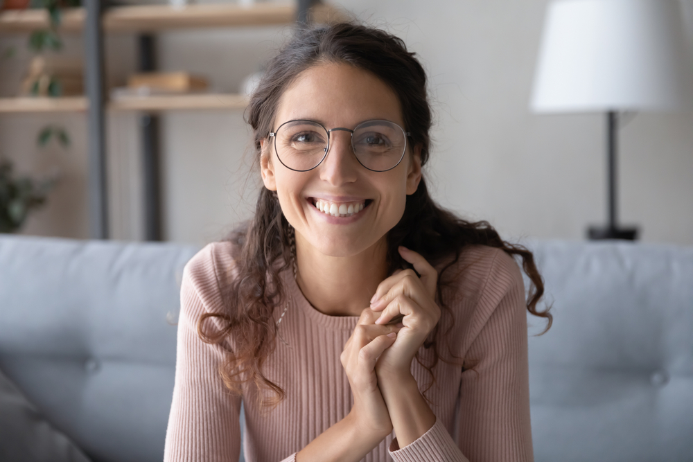 Smiling woman relaxing at home, representing the confident smile cosmetic dentistry in the San Diego community can help achieve 