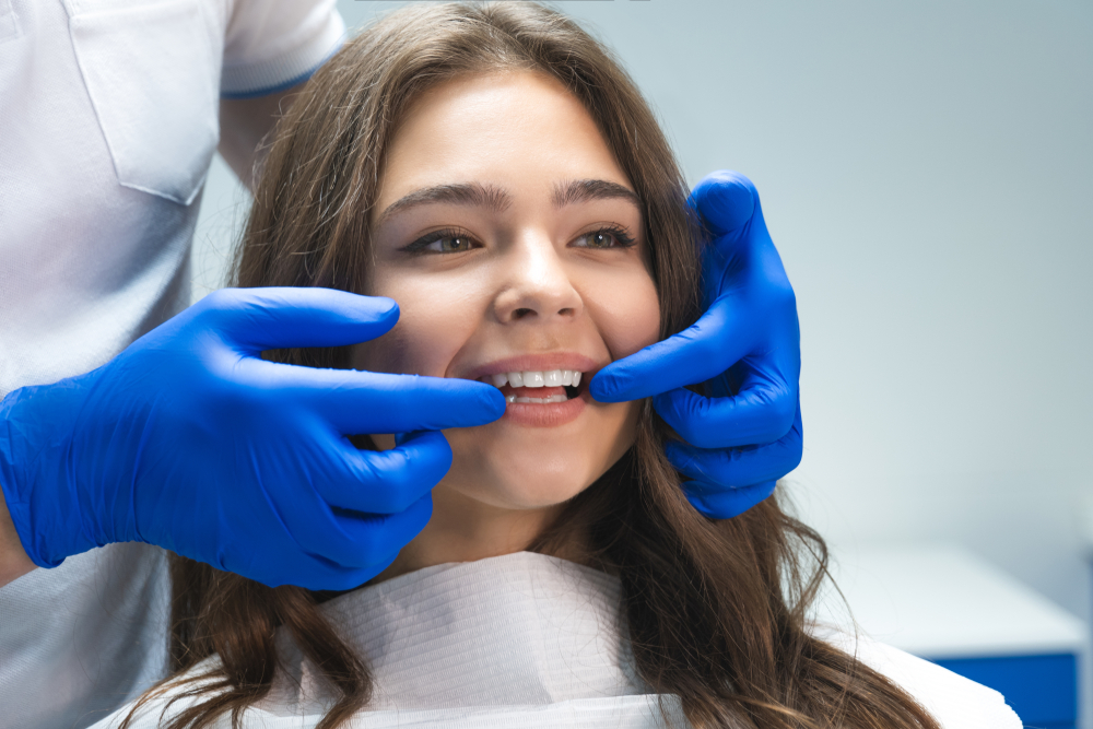 Dental Exam: Dentist Checking Patient's Teeth in the San Diego Community Dentist checking a smiling patient's teeth during a dental exam in the San Diego community
