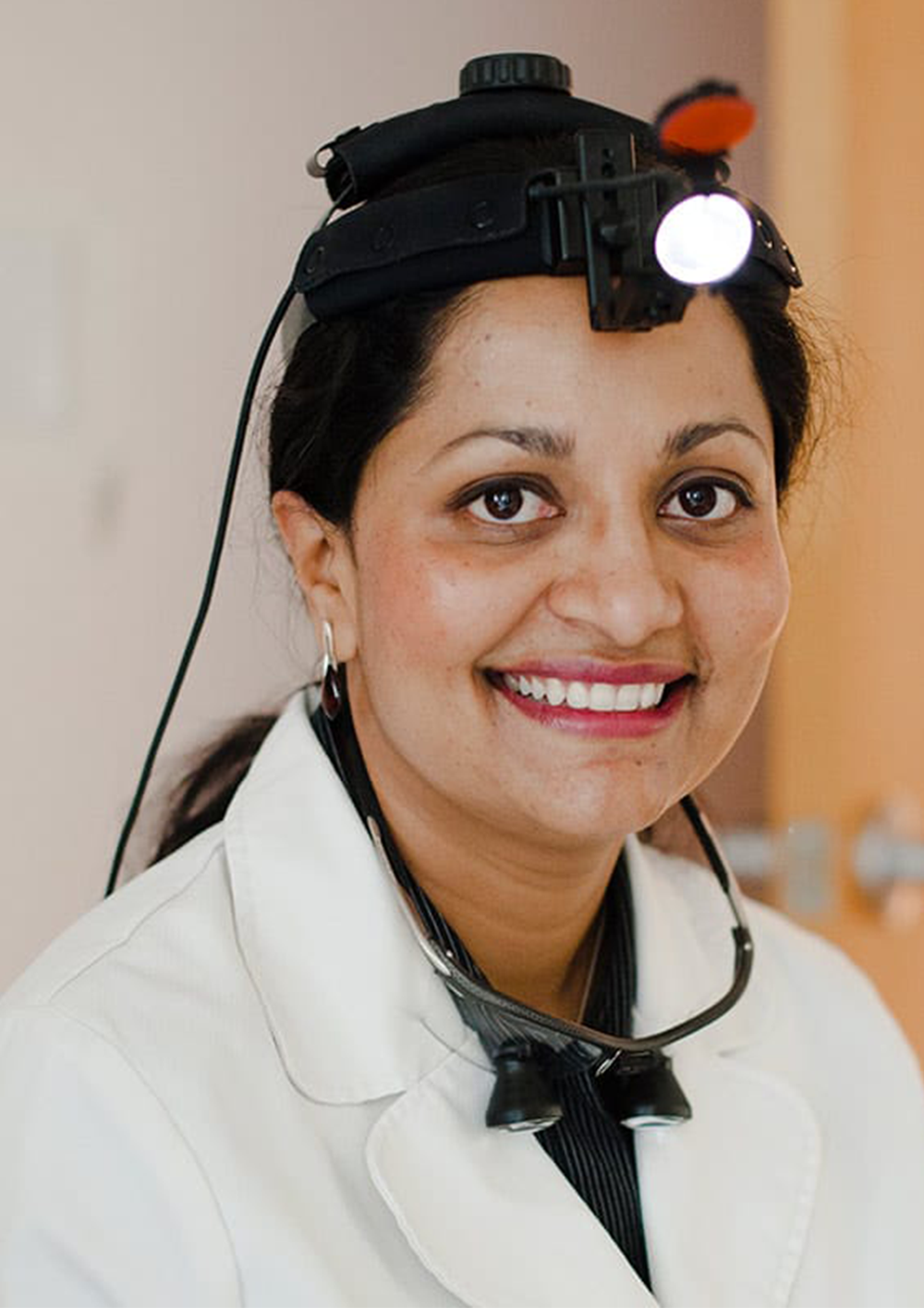 Dr. Sandhya Hegde wearing dental loupes and a white coat at Center for Dental Health La Jolla in San Diego
